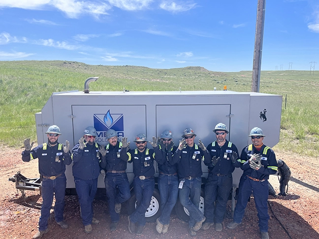 Mesa Solutions Generator Technicians in front of a Natural Gas Generator